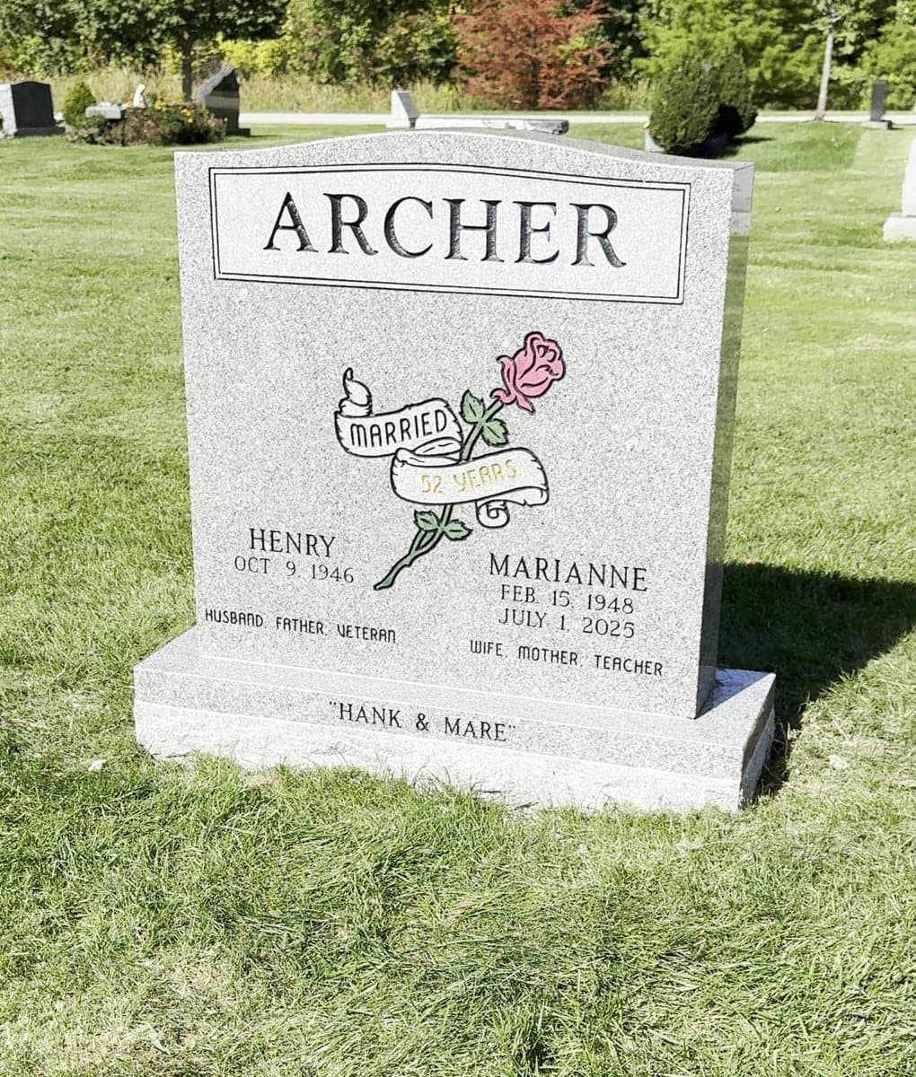 The finished ARCHER granite headstone in a cemetery, with a hand-painted pink rose and a Married 52 Years banner